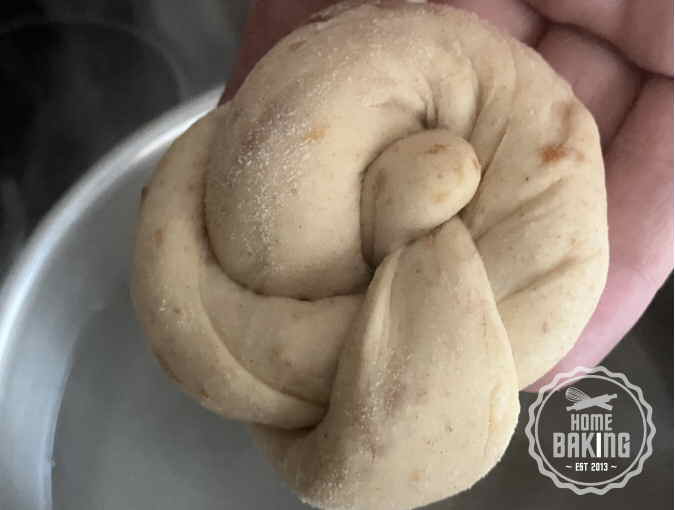Pretzel Roll being placed into a hot water and Bicarbonate